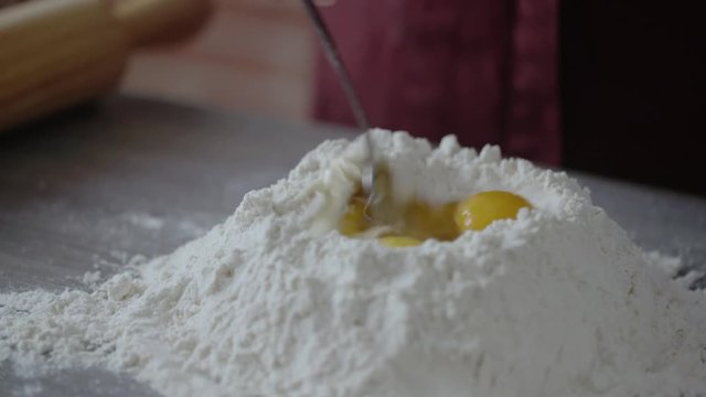 Man preparing dough on kitchen table, close up view
