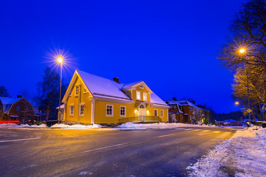 Winter scenery with yellow wooden house at night in Sweden