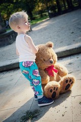 Junge steht mit Pl&uuml;schtier