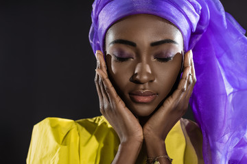 close-up shot of young african american woman in stylish wire head wrap isolated on black