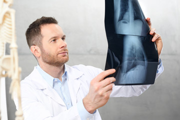Ortopeda.
Lekarz w gabinecie lekarskim ogląda zdjęcie rentgenowskie pacjenta.
 - obrazy, fototapety, plakaty