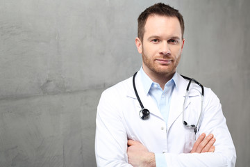 Fototapeta Lekarz.
Przystojny lekarz ubrany w biały kitel stoi w klinice
 obraz
