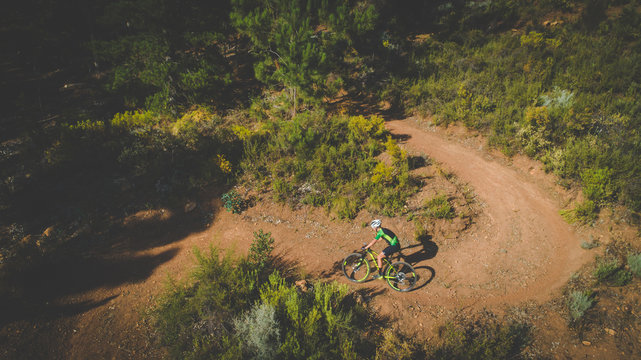 Aerial view of a mountain biker speeding downhill on a mountain bike track in the woods