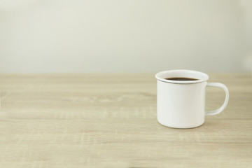 ENAMEL COFFEE MUG
Enamel white coffee mug on a wood table.