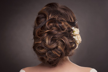 head of woman with hair in wedding bun on gray isolated background rear view of brown hair