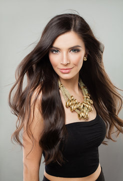 Young Attractive Woman with Long Healthy Hair and Golden Necklace