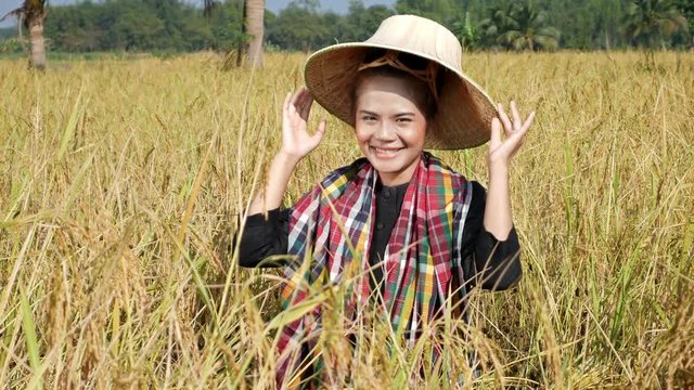 4k video of farmer woman smiling and looking around in rice field, Thailand