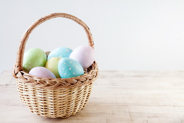 Colorful easter eggs in basket on wooden table. Happy easter. Top view with copy space. Orthodox holiday.
