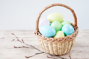 Colorful easter eggs in basket on wooden table. Happy easter. Top view with copy space. Orthodox holiday.
