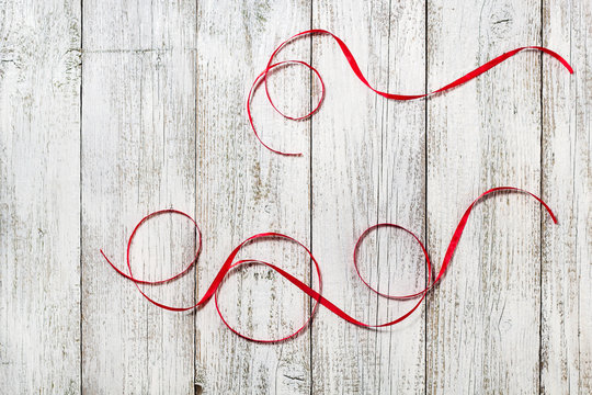 Red ribbons on the white wooden background