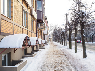 Snow-covered city street with cars.
