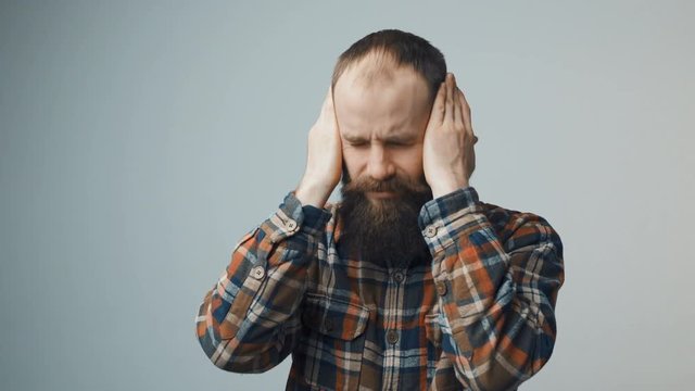 Bearded hipster man suffering from headache emotional stress