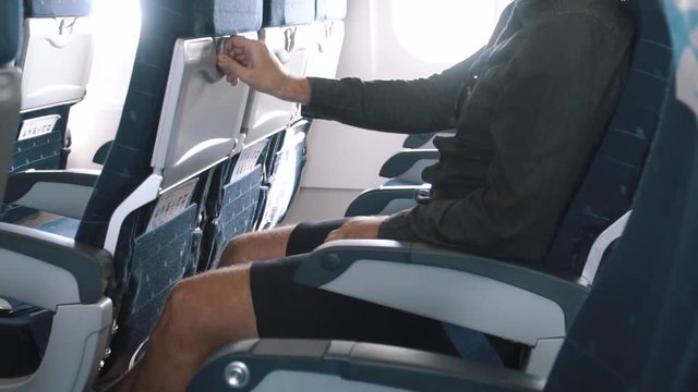 Male Passenger Opens Table in Airplane