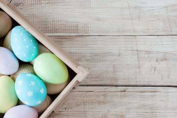 Easter eggs in a basket on rustic wooden background, selective focus image, Happy Easter. Space for text.