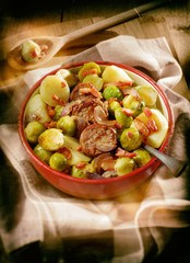 Sausage and sprouts meal in rustic enamel bowl. Filter effects.