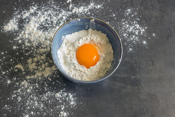 Eggs and flour in the blue bowl. Ingredients for home baking. Delicious Breakfast.