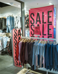 big letters indicate sale in shop windows of clothing store