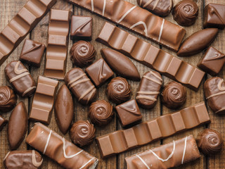 Background of chocolates, bars and sweets, free space for text, close up