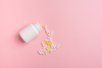 Creative concept Illness:  vitamins in a jar on pink background