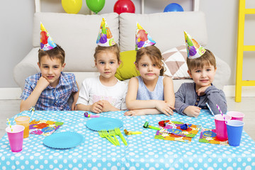 Happy group of children celebrating friends birthday. Kids party