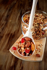 Granola in a glass jar and a wooden spoon. Rustic style