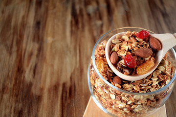 Granola in a glass jar and a wooden spoon. Rustic style
