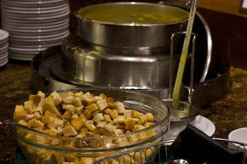 Soup in the hotel restaurant in a silver soup tureen. Glass bowls with croutons