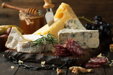 Assorted cheeses with grapes, nuts and rosemary