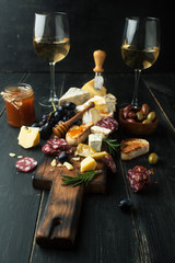 Assorted cheeses with grapes, nuts and rosemary