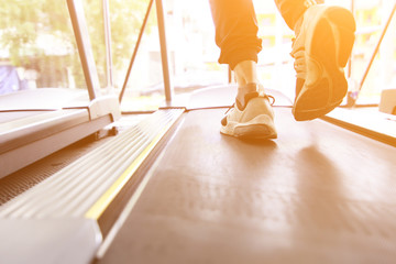 Feet of male athlete walking or running on treadmill, close up feet running on treadmill.