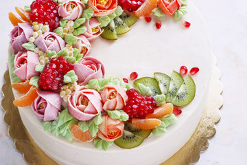 Festive cake with cream flowers and fruits on a light background