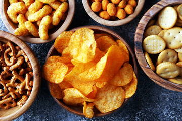 Salty snacks. Pretzels, chips, crackers in wooden bowls.