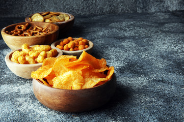 Salty snacks. Pretzels, chips, crackers in wooden bowls.
