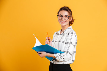 Cheerful young woman holding folder and pen.