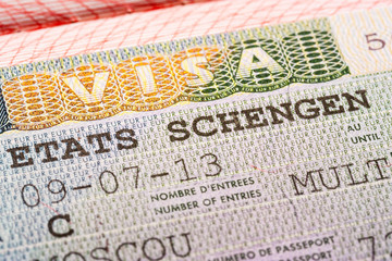 Schengen Visa in a passport, closeup, selective focus.