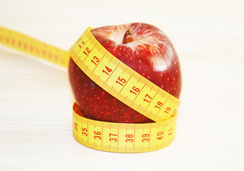 red apple with tape measure - weight loss - diet concept