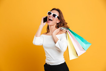 Cheerful young woman holding shopping bags