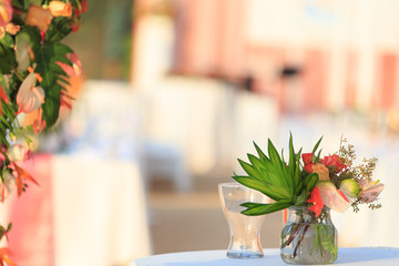 Bouquet flowers in glass vase on the table for wedding ceremony. Wedding decoration with flowers in glass vase on the table.