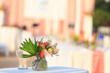Bouquet flowers in glass vase on the table for wedding ceremony. Wedding decoration with flowers in glass vase on the table.