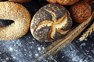 Different kinds of bread and bread rolls on board from above. Kitchen or bakery poster design.