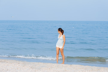 Happy woman on the beach. Portrait of the beautiful girl close-up, the wind fluttering hair. Spring portrait on the beach. Summer portrait