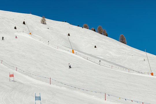 Dolomites, ski area with beautiful slopes and blue sky. Ski slope in winter on a sunny day. Prepare ski slope, Alpe di Lusia, Italy
