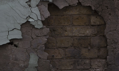 Textured wall with falling plaster and old brick.