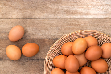 Group of chicken eggs for cook and sale in basket on wooden table background. Egg have protein and nutritional value in local farm in Thailand. Soft focus and copy space.