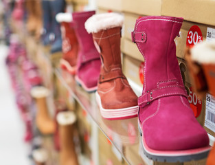 Collection of different winter kids shoes in shop.