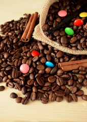 Coffee beans, multicoloured drops, cinnamon and vanilla. Ingredients for making a drink