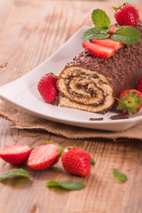 Chocolate roll with hazelnuts and strawberries. 