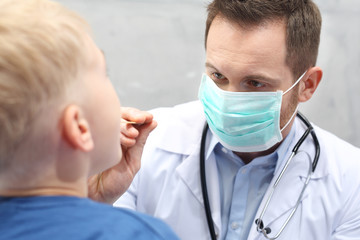 Chore gardło u dziecka. Pediatra sprawdza gardo chłopca - obrazy, fototapety, plakaty