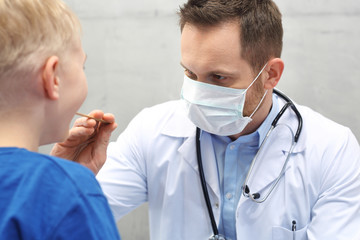 Dziecko u lekarza.  Chore gardło u dziecka. Pediatra sprawdza gardo chłopca - obrazy, fototapety, plakaty