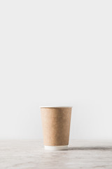 disposable coffee cup on marble table on white